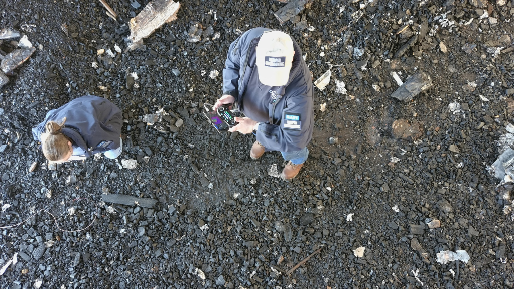 Overhead imagery of the KES team (San Miguel and Kemper) surrounded by burnt debris.